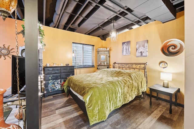 bedroom with beam ceiling and wood finished floors