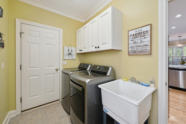 laundry room with crown molding, cabinet space, a sink, separate washer and dryer, and recessed lighting