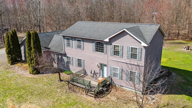 57480 72nd Ave, Hartford, MI 49057 - back of house featuring a shingled roof, a deck, a view of trees, and a lawn