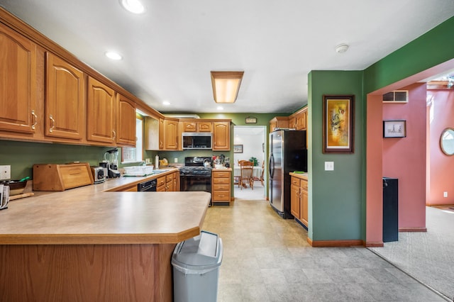 57480 72nd Ave, Hartford, MI 49057 - kitchen with a peninsula, light countertops, visible vents, brown cabinets, and black appliances