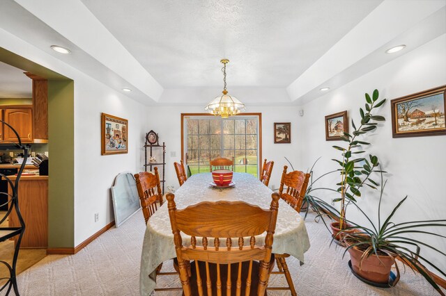 57480 72nd Ave, Hartford, MI 49057 - dining space featuring a tray ceiling, baseboards, a chandelier, and light carpet