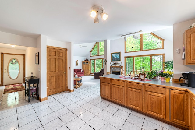 5095 Bliss Ln, Newaygo, MI 49337 - kitchen with light tile patterned floors, brown cabinetry, a peninsula, and lofted ceiling