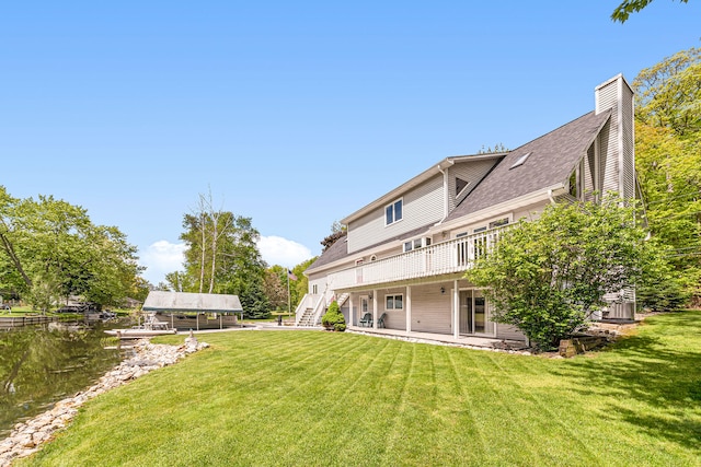 5095 Bliss Ln, Newaygo, MI 49337 - rear view of house with roof with shingles, a chimney, stairway, a deck, and a lawn