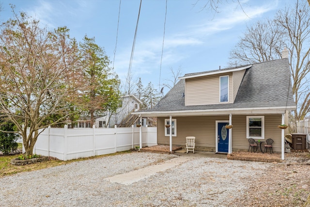 back of house featuring fence and a shingled roof