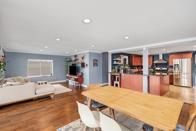 dining space with crown molding, light wood finished floors, baseboards, and recessed lighting