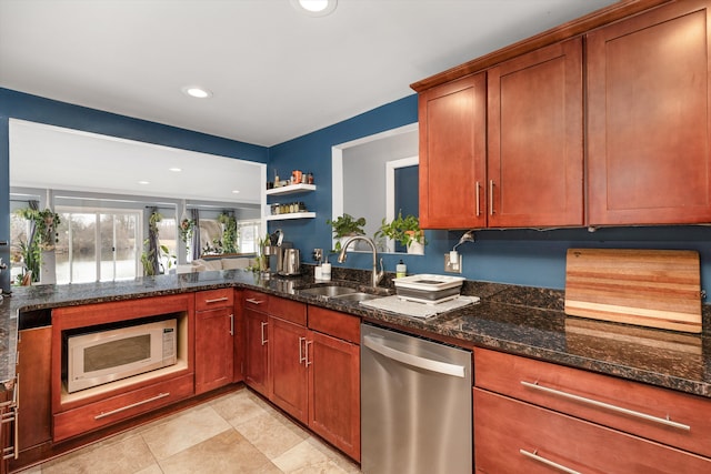 kitchen featuring dark stone countertops, open shelves, dishwasher, a sink, and white microwave