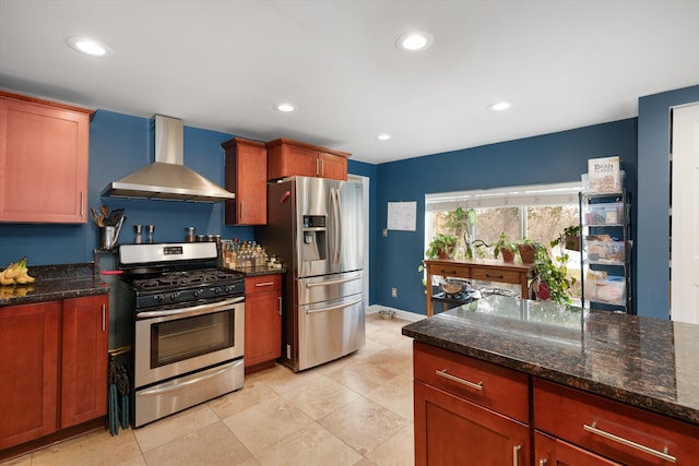 kitchen with wall chimney range hood, recessed lighting, dark stone countertops, stainless steel appliances, and baseboards