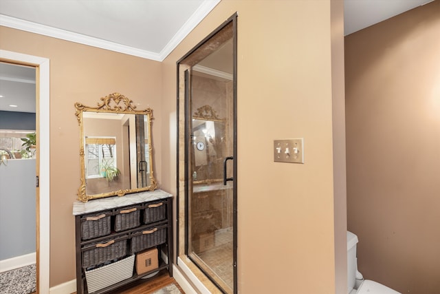 full bath featuring a shower stall, crown molding, baseboards, and toilet