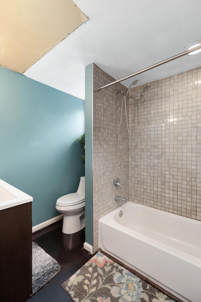 full bath with toilet, wood finished floors, tub / shower combination, and baseboards