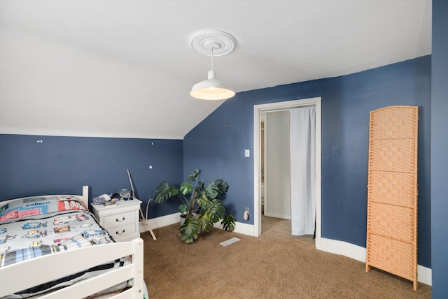 carpeted bedroom with baseboards, lofted ceiling, and visible vents