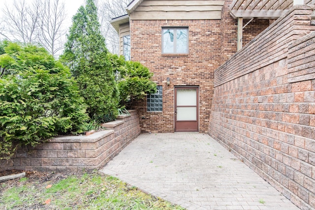 doorway to property with a patio and brick siding