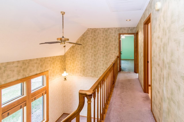 hall featuring light carpet, plenty of natural light, wallpapered walls, and lofted ceiling