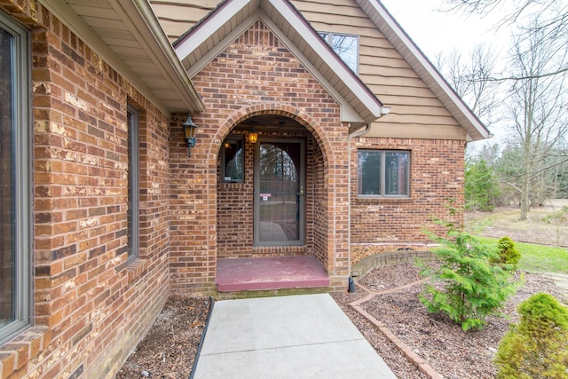 view of exterior entry featuring brick siding