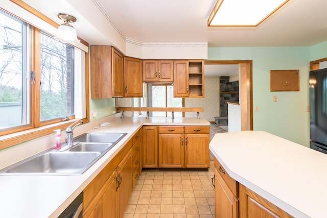 kitchen with light countertops, a healthy amount of sunlight, light tile patterned flooring, and a sink