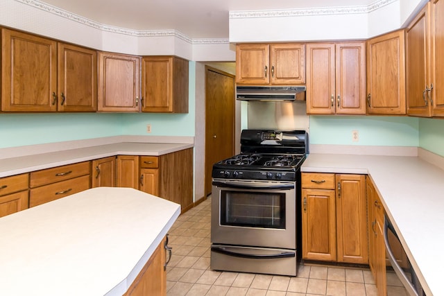kitchen with brown cabinets, appliances with stainless steel finishes, light countertops, and under cabinet range hood