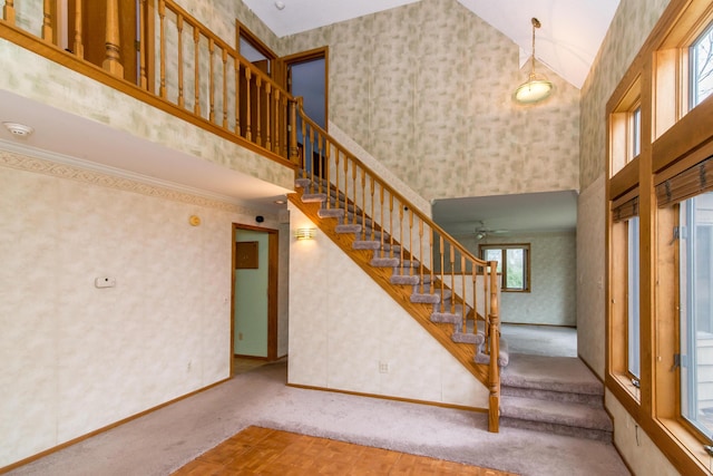 stairs featuring wallpapered walls, high vaulted ceiling, and carpet floors