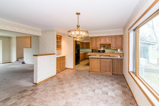 kitchen with a chandelier, a peninsula, freestanding refrigerator, and plenty of natural light