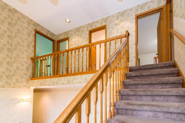 stairs with wallpapered walls, ceiling fan, and recessed lighting