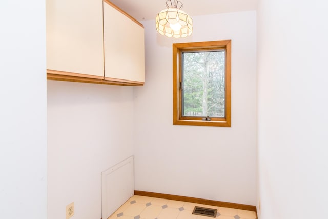 interior space featuring visible vents, baseboards, and light floors