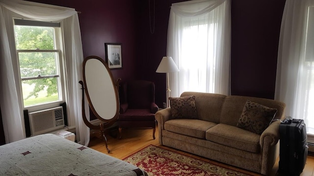 sitting room featuring cooling unit and wood finished floors