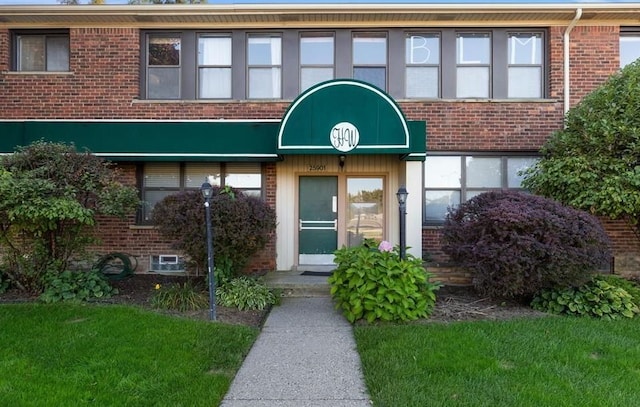 doorway to property featuring brick siding