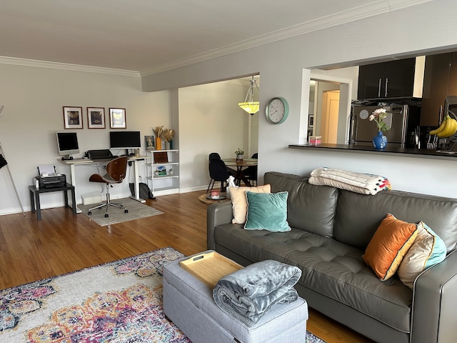 living area featuring baseboards, ornamental molding, and wood finished floors