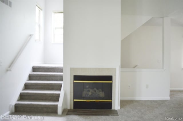12201 Pinehurst Ln, Grand Blanc, MI 48439 - unfurnished living room featuring a fireplace, stairway, carpet floors, and baseboards