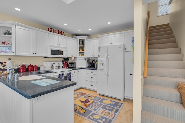 kitchen featuring a sink, open shelves, white appliances, and a peninsula