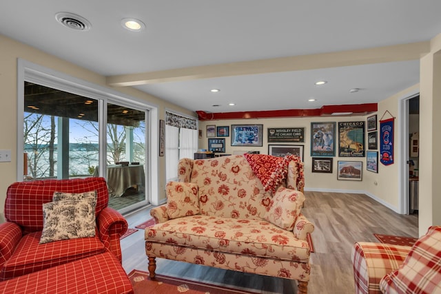 living room with visible vents, baseboards, recessed lighting, and wood finished floors