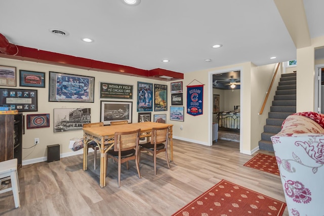 dining room featuring visible vents, baseboards, stairway, and wood finished floors