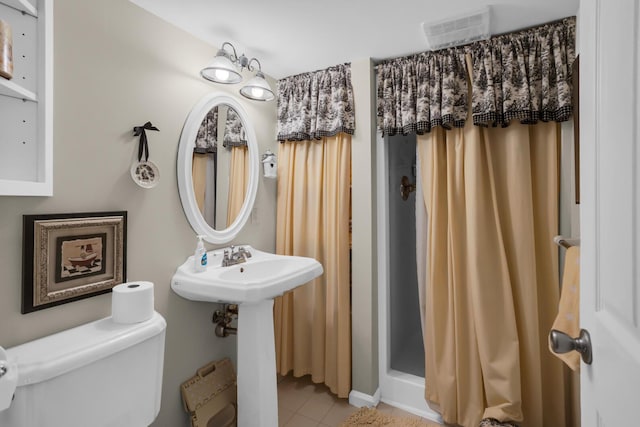 full bathroom with visible vents, a sink, toilet, tile patterned floors, and a stall shower