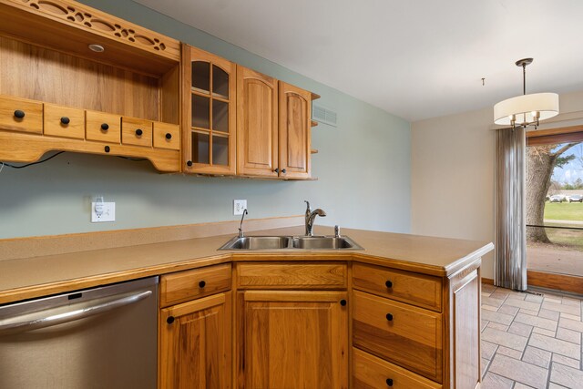kitchen with stainless steel dishwasher, stone finish flooring, visible vents, light countertops, and a sink