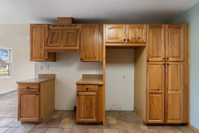 kitchen with stone tile flooring and brown cabinetry
