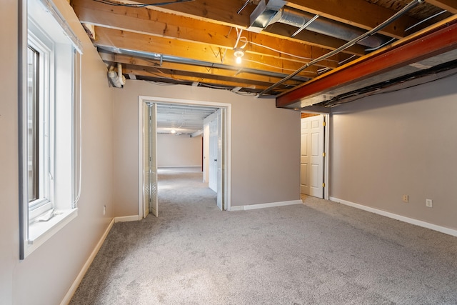 below grade area with plenty of natural light, carpet flooring, and baseboards