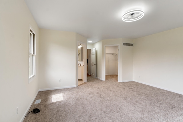 unfurnished bedroom with visible vents, baseboards, and light carpet