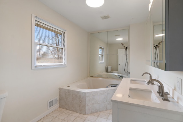 bathroom featuring tile patterned flooring, visible vents, a garden tub, and toilet