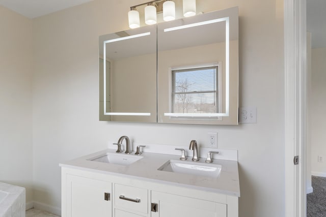 bathroom with double vanity, baseboards, and a sink