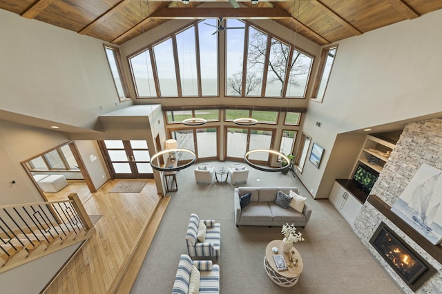 living room with high vaulted ceiling, a fireplace, wood ceiling, and ceiling fan
