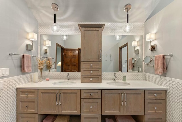 bathroom with double vanity, a sink, and tile walls