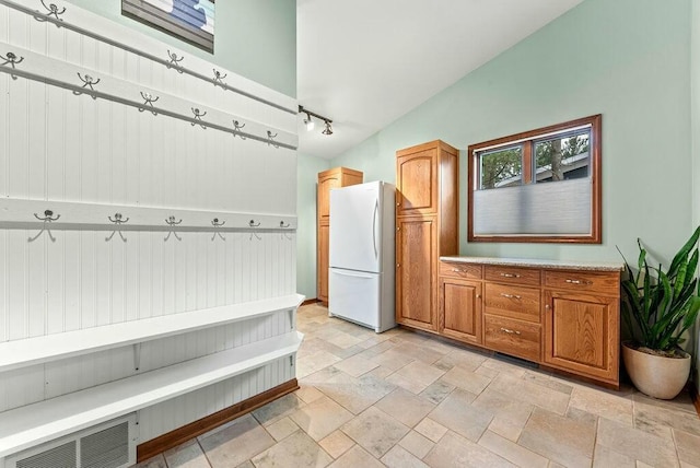 mudroom featuring visible vents, rail lighting, and stone tile floors