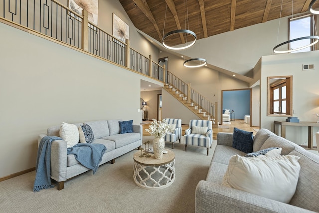 carpeted living room featuring visible vents, baseboards, wooden ceiling, stairway, and high vaulted ceiling