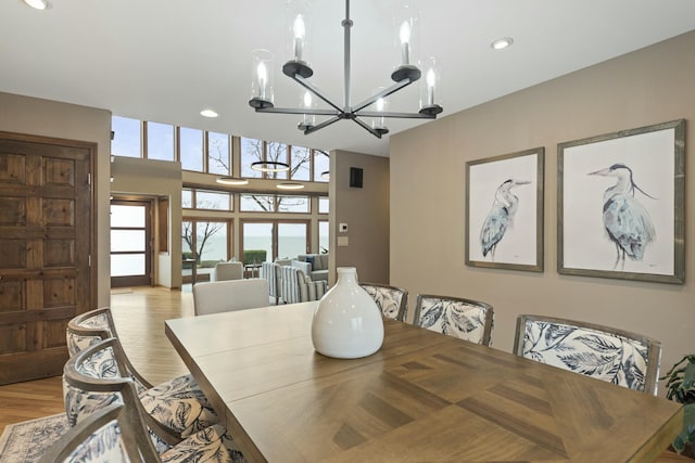 dining area with recessed lighting, a notable chandelier, and light wood finished floors