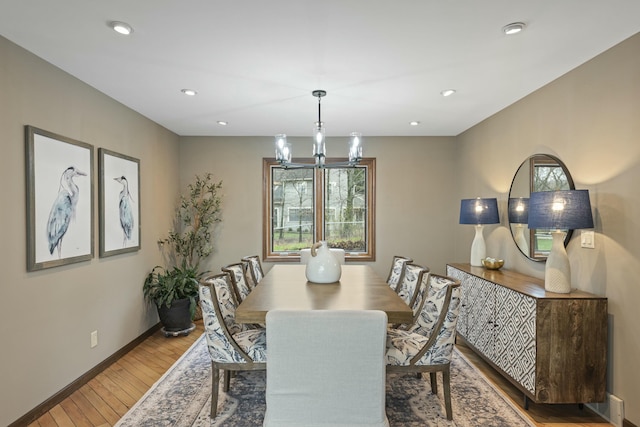 dining room featuring recessed lighting, light wood finished floors, a notable chandelier, and baseboards