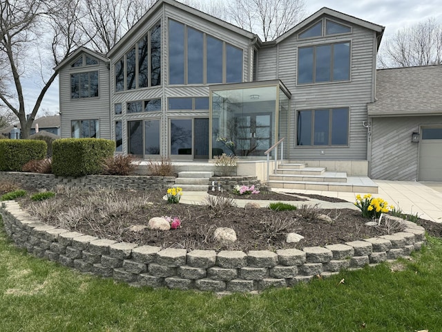 rear view of house with an attached garage and a sunroom