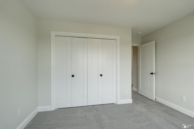 unfurnished bedroom featuring a closet, baseboards, and carpet