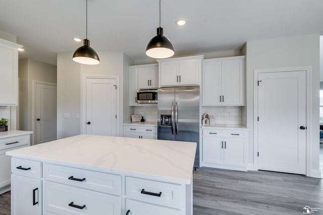 kitchen featuring decorative light fixtures, backsplash, and appliances with stainless steel finishes
