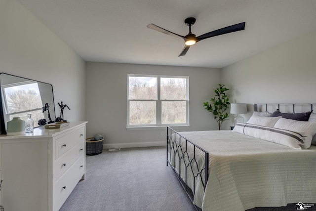 bedroom with baseboards, a ceiling fan, and light colored carpet