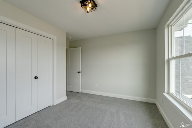 unfurnished bedroom with a closet, baseboards, and carpet