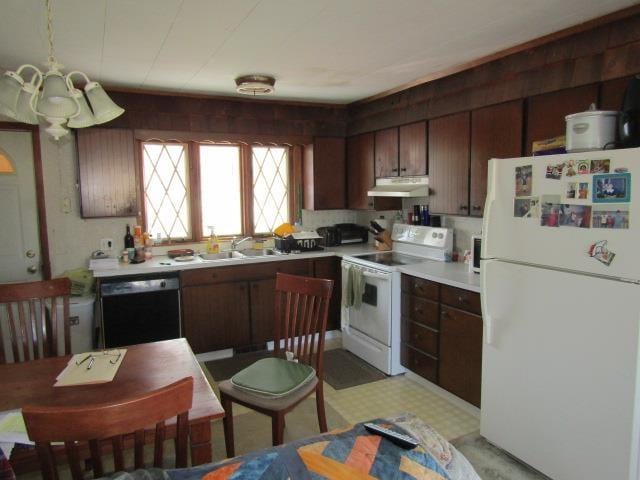 kitchen with a sink, light countertops, white appliances, and under cabinet range hood