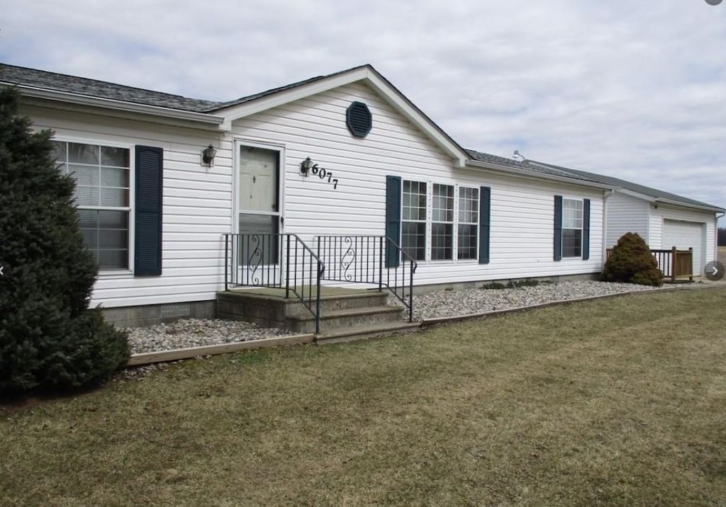 view of front of home with an attached garage and a front lawn